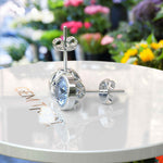 Load image into Gallery viewer, Azure Brilliance: Blue Moissanite Stud Earrings with Delicate Migraine Halo.