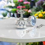 Load image into Gallery viewer, Azure Brilliance: Blue Moissanite Stud Earrings with Delicate Migraine Halo.