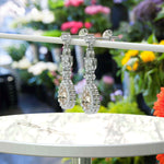 Load image into Gallery viewer, Golden Whispers: Pear Cut Champagne Moissanite Halo Drop Earrings Accented with Marquise Moissanites.