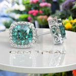 Load image into Gallery viewer, Ocean Radiance: Lustrous Cushion Cut Cyan Blue Moissanite Earrings in a Sparkling Halo.