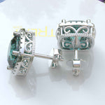 Load image into Gallery viewer, Ocean Radiance: Lustrous Cushion Cut Cyan Blue Moissanite Earrings in a Sparkling Halo.