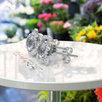 Load image into Gallery viewer, Silver Moonlight: Round Gray Moissanite Stud Earrings with Double Moissanite Halo Sparkle.