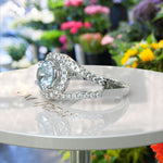 Load image into Gallery viewer, Harbor of Light: Silver Halo Ring with 1ct Round Aquamarine and Dazzling Moissanites on Split Shank
