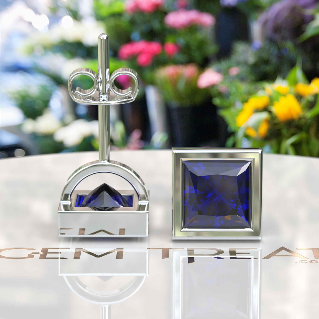 Earrings of Royalty: Bezel-Encased Princess Cut Blue Sapphire Studs.