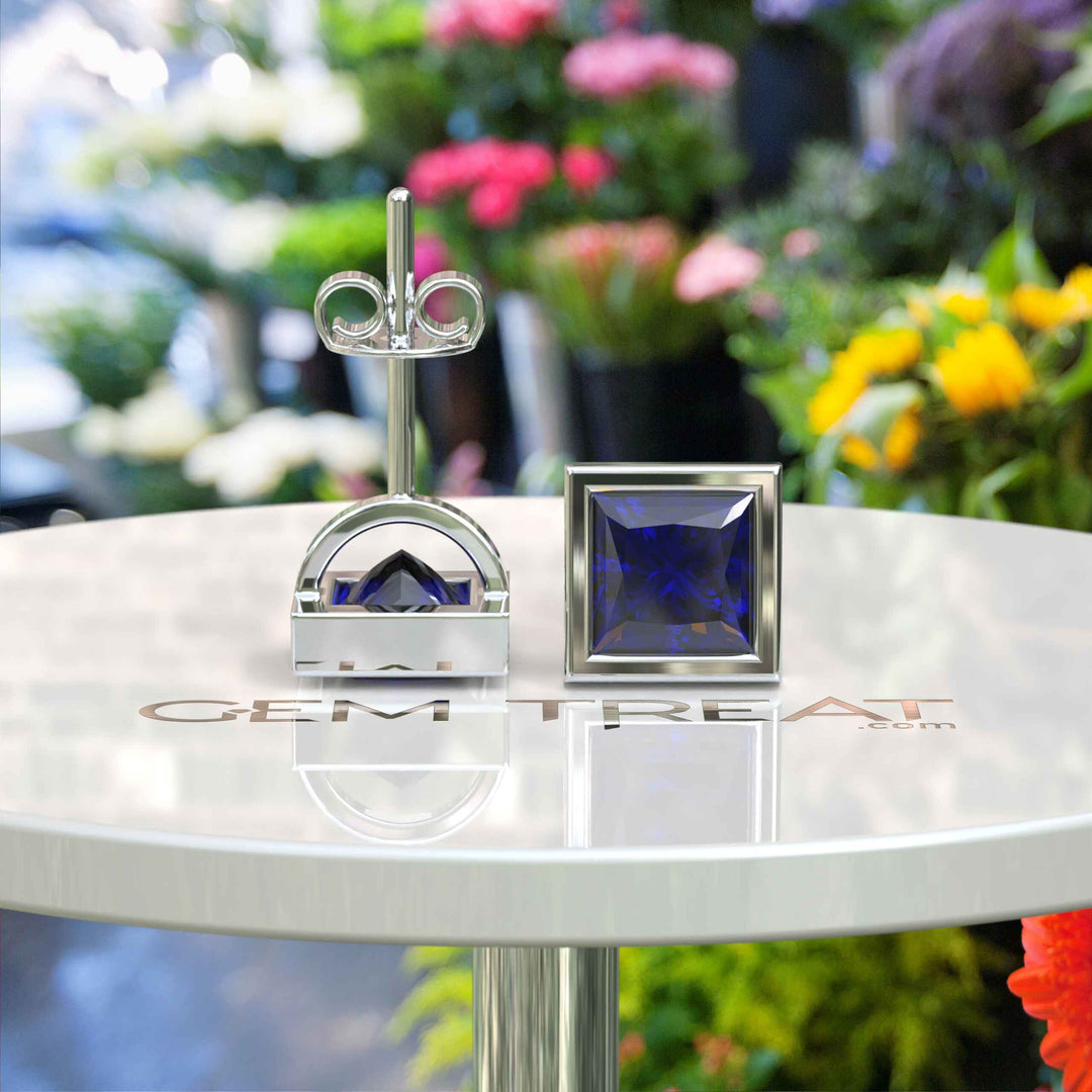 Earrings of Royalty: Bezel-Encased Princess Cut Blue Sapphire Studs.