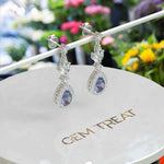 Load image into Gallery viewer, Spectral Elegance: Pear Cut Alexandrite Drop Earrings with Moissanite Halo.
