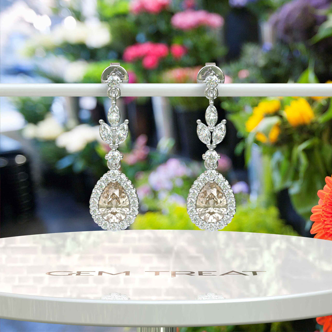 Golden Whispers: Pear Cut Champagne Moissanite Halo Drop Earrings Accented with Marquise Moissanites.