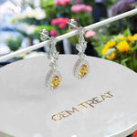 Load image into Gallery viewer, Golden Radiance: Pear Cut Citrine Drop Earrings with Sparkling Moissanite Halo.
