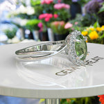 Load image into Gallery viewer, Green Oasis &amp; Spiraled Elegance: Halo Ring Spotlighting Oval Peridot with Twisted Shank
