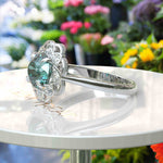 Load image into Gallery viewer, Garden of Glow: Floral Style Halo Ring with Dazzling Portuguese Cut Cyan Blue Moissanite in Silver
