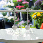 Load image into Gallery viewer, Classic Meets Sparkle: Pearl Drop Earrings with Moissanite Centerpiece.
