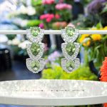 Load image into Gallery viewer, Nature’s Sparkle: Peridot Pear Hoop Earrings with Moissanite Halo.
