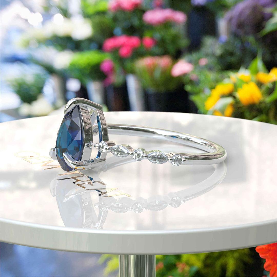 Deep Sea Elegance: Pear Cut London Blue Topaz Ring with Marquise Moissanite Accents in Silver