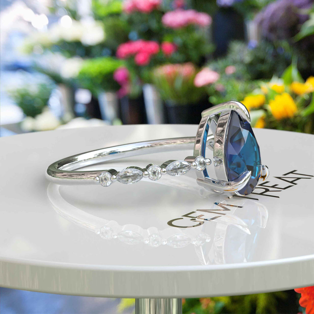 Deep Sea Elegance: Pear Cut London Blue Topaz Ring with Marquise Moissanite Accents in Silver