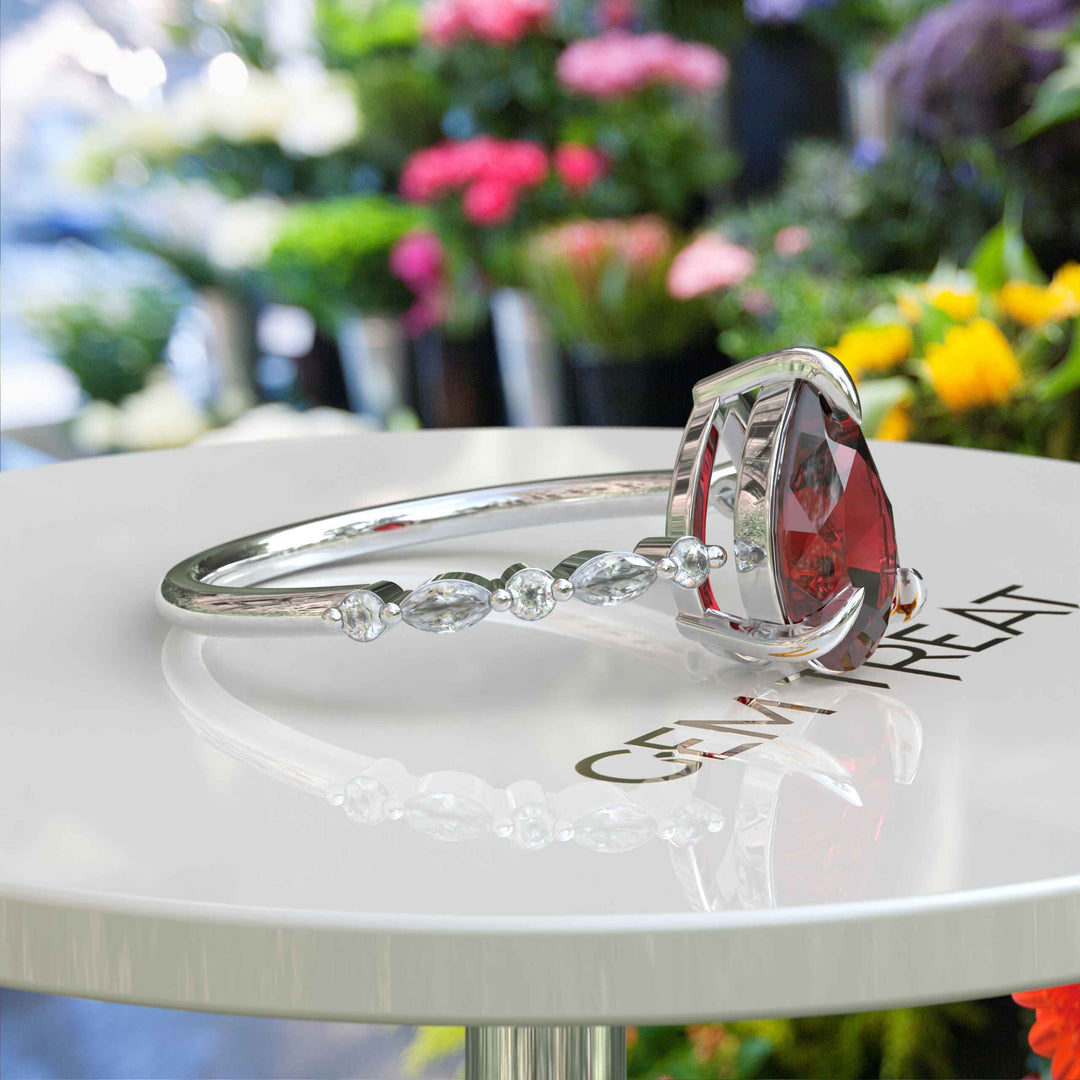 Gems of Desire and Dreams: Pear Cut Ruby Ring Elegance, Elevated by Marquise Moissanite Details