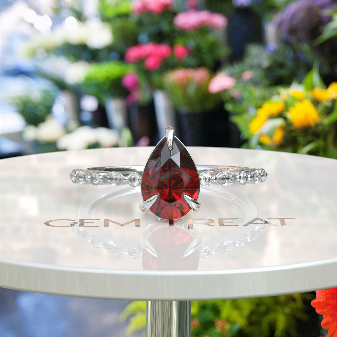 Gems of Desire and Dreams: Pear Cut Ruby Ring Elegance, Elevated by Marquise Moissanite Details