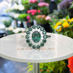 Load image into Gallery viewer, Emerald Oasis: Double Halo Oval Green Emerald Ring with Moissanite &amp; Emerald Embellishments.
