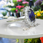 Load image into Gallery viewer, The Pinnacle of Romance: 4.0ct Oval Blue Sapphire Halo Ring Adorned with Moissanite Accents.
